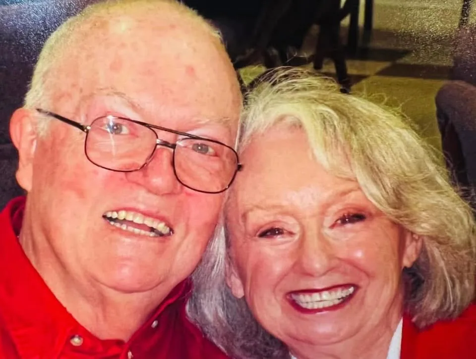 Brenda smiling closely beside an older man in a warm candid photograph